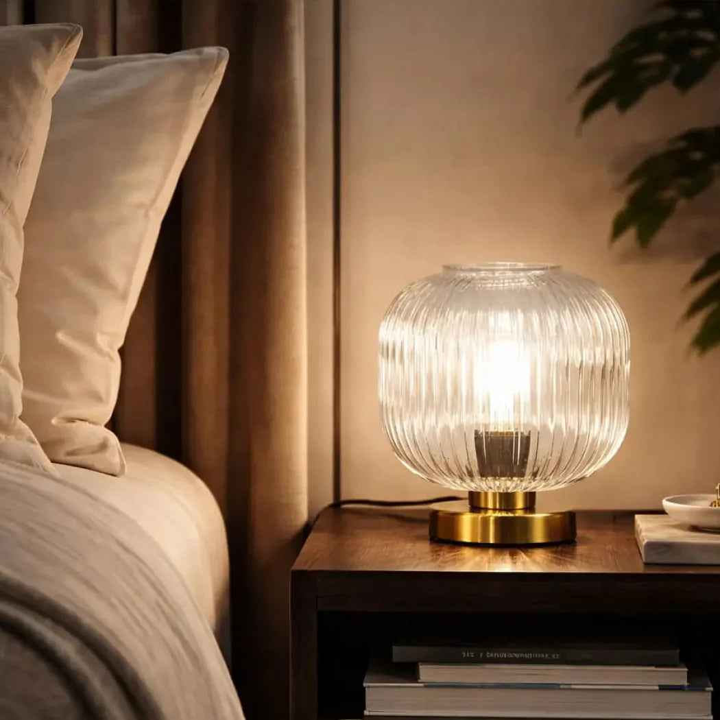HALO Table Lamp in bedroom – clear glass globe on gold metal frame, warm bedside lighting